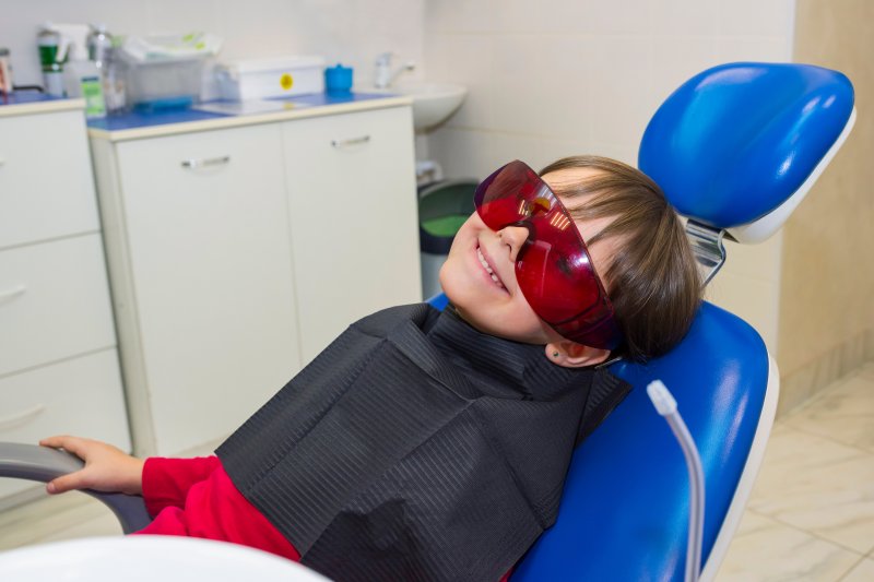 child sitting in the dentist’s chair smiling