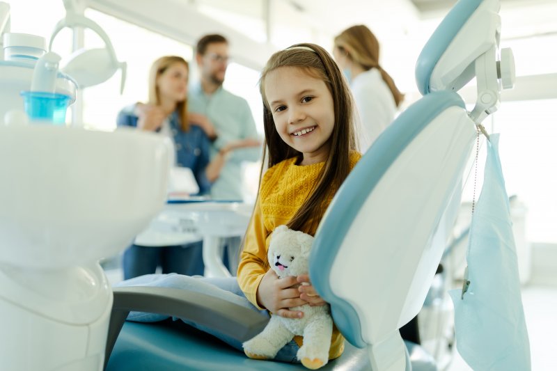 child sitting in treatment chair and smiling